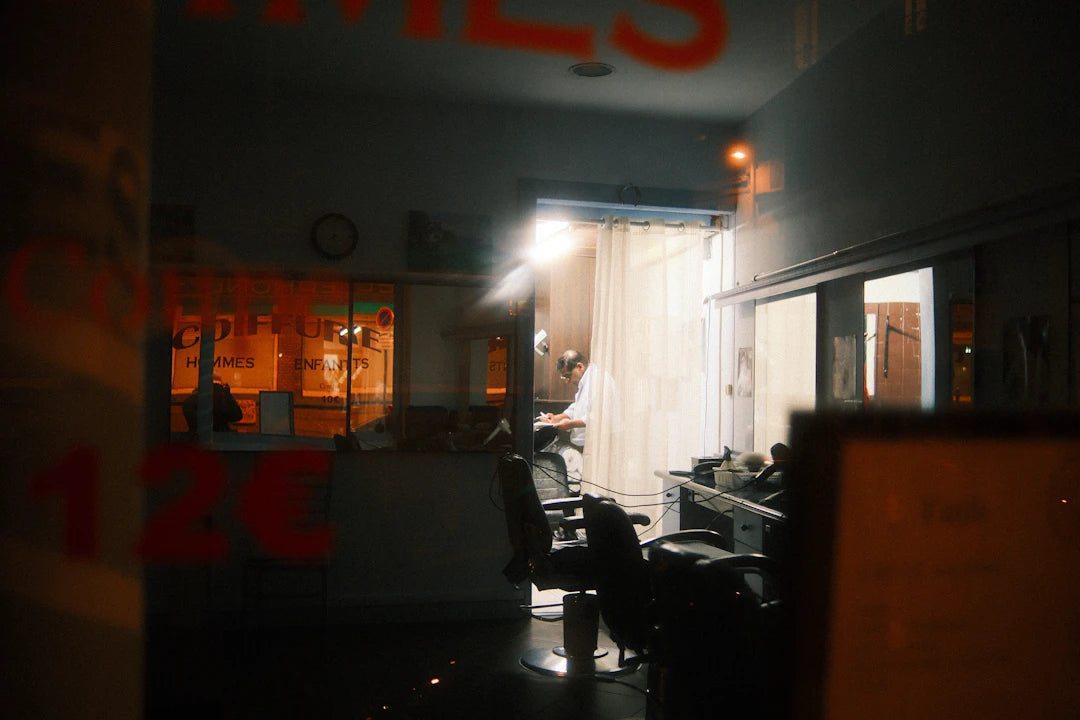 View through a window of a barber shop at night